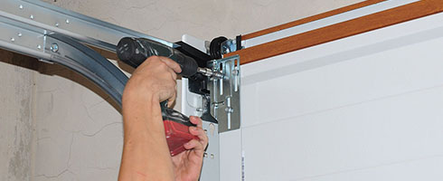 Repairman repair garage door opener. Garage door replacement, garage door repair.